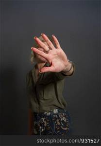Adult woman shows stopping or prohibiting gesture with hand. gesture no girl