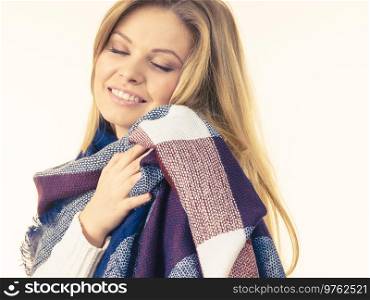 Adult woman wearing fashionable autumn outfit, white sweater and long beautiful warm colorful soft scarf.. Woman wearing warm soft scarf
