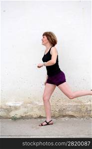 adult women jogging by wall in city