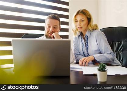 Adult young caucasian man and woman working at the office in day