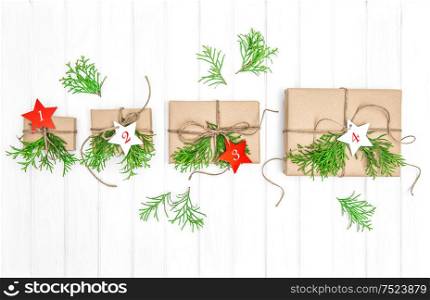 Advent calendar. Gifts with christmas decoration and evergreen branches on bright wooden background