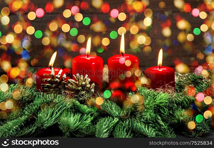 Advent decoration with four red burning candles and colorful lights. Holidays background. Selective focus, vintage style toned picture