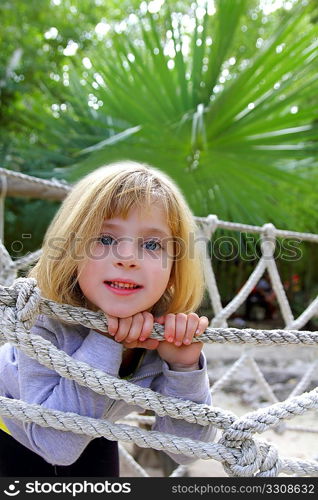 adventure blond happy little girl on jungle park rope bridge