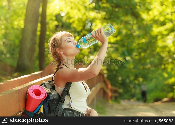 Adventure, tourism, enjoying summer time - young tourist hiker woman with backpack water bottle in forest trail