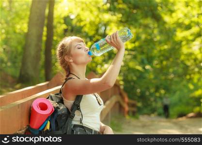 Adventure, tourism, enjoying summer time - young tourist hiker woman with backpack water bottle in forest trail