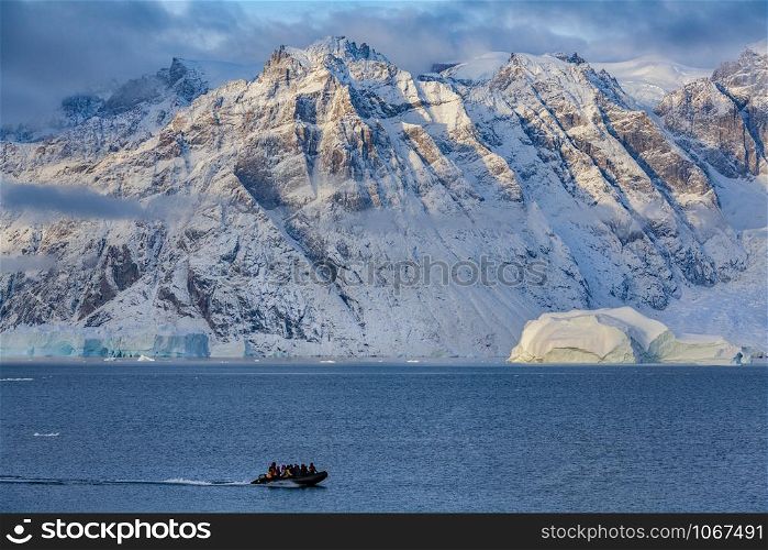 Adventure tourists in Scoresbysund in eastern Greenland in the late afternoon sunlight.