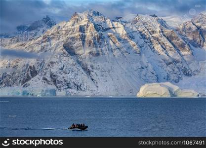 Adventure tourists in Scoresbysund in eastern Greenland in the late afternoon sunlight.