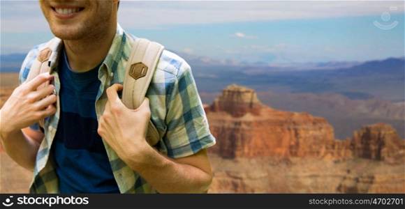 adventure, travel, tourism, hike and people concept - close up of smiling young man with backpack over grand canyon national park background. close up of man with backpack over grand canyon. close up of man with backpack over grand canyon