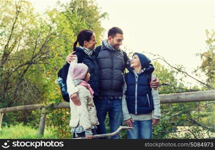 adventure, travel, tourism, hike and people concept - happy family walking with backpacks in woods. happy family with backpacks hiking. happy family with backpacks hiking