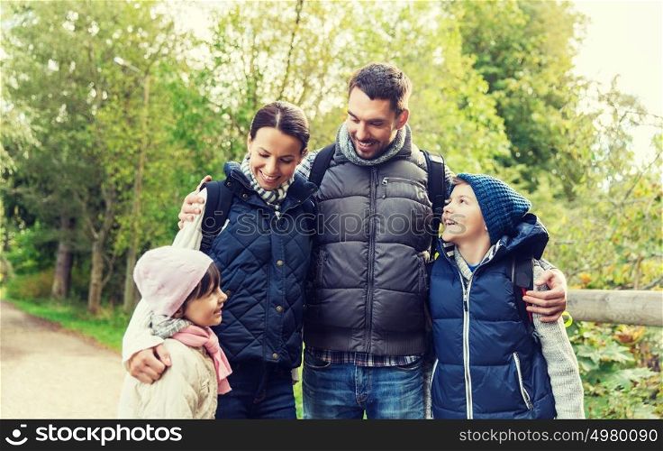 adventure, travel, tourism, hike and people concept - happy family with backpacks in woods. happy family with backpacks hiking