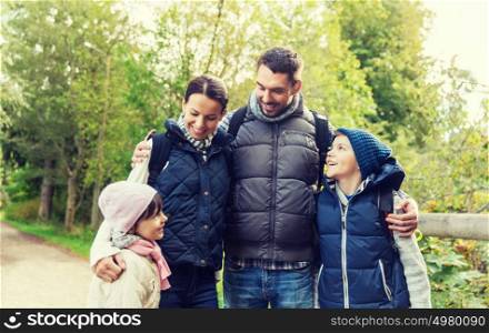 adventure, travel, tourism, hike and people concept - happy family with backpacks in woods. happy family with backpacks hiking