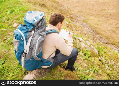 adventure, travel, tourism, hike and people concept - man with backpack sitting on ground from back