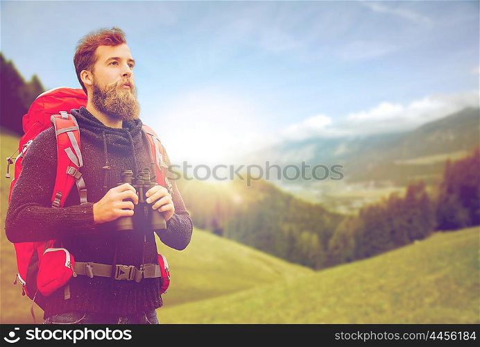 adventure, travel, tourism, hike and people concept - man with red backpack and binocular over alpine mountains and hills background