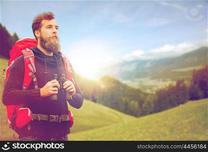 adventure, travel, tourism, hike and people concept - man with red backpack and binocular over alpine mountains and hills background