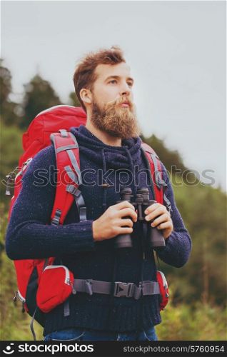 adventure, travel, tourism, hike and people concept - man with red backpack and binocular outdoors
