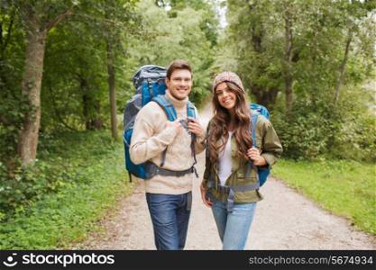 adventure, travel, tourism, hike and people concept - smiling couple with backpacks outdoors