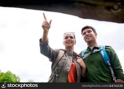 adventure, travel, tourism, hike and people concept - smiling couple with backpacks standing at signpost outdoors