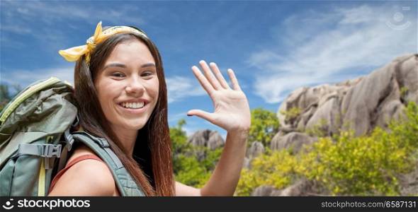 adventure, travel, tourism, hike and people concept - smiling young woman with backpack over background of seychelles island. happy woman with backpack over seychelles island