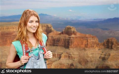 adventure, travel, tourism, hike and people concept - smiling young woman with backpack over grand canyon national park background. smiling woman with backpack over grand canyon