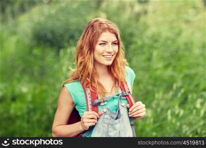 adventure, travel, tourism, hike and people concept - smiling young woman with backpack hiking in woods