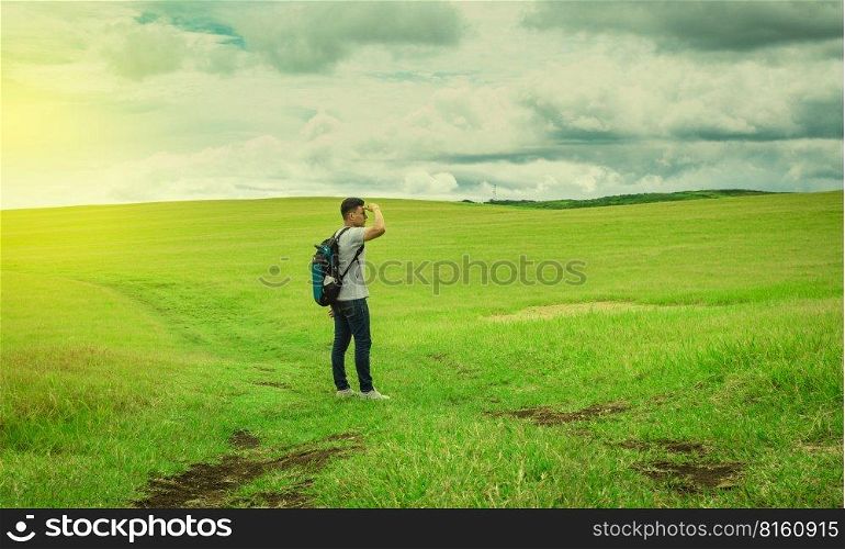 Adventurous man in the field, man with backpack in the field looking