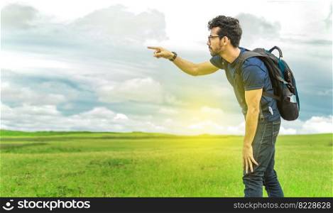 Adventurous man in the field, man with backpack in the field looking
