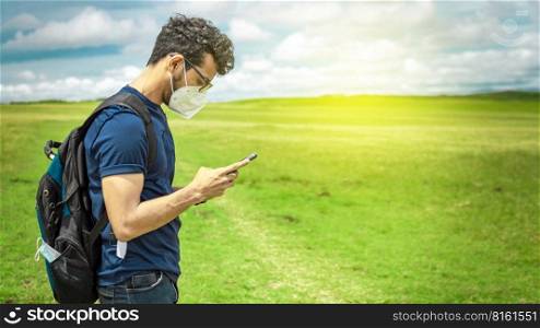 Adventurous man in the field with phone, man with backpack in the field chatting