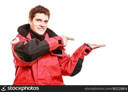 Adventurous man making gesture. Adventurous man making gesture showing open palm with space for product. Young male in weatherproof clothing. Adventure communication outdoors danger concept.