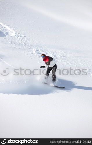 Adventurous man snowboarding down hill