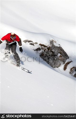 Adventurous man snowboarding downhill