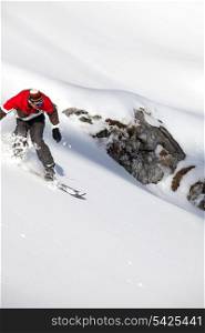 Adventurous man snowboarding downhill