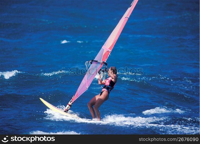 Adventurous windsurfer windsurfing on ocean