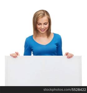 advertisement and people concept - smiling girl looking down at blank white board
