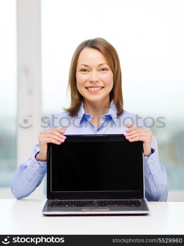 advertisement, business and technology concept - smiling businesswoman with blank black laptop screen