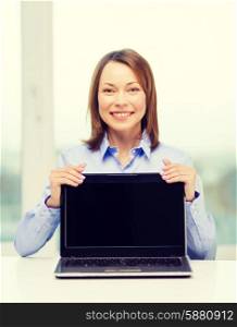 advertisement, business and technology concept - smiling businesswoman with blank black laptop screen