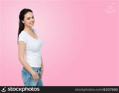 advertisement, clothing and people concept - happy smiling young woman or teenage girl in white t-shirt over pink background