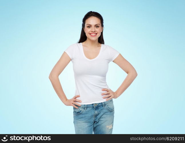 advertisement, clothing and people concept - happy smiling young woman or teenage girl in white t-shirt over blue background