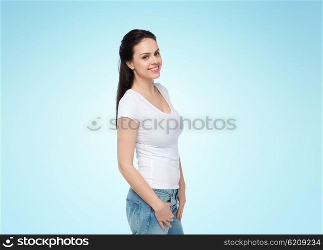 advertisement, clothing and people concept - happy smiling young woman or teenage girl in white t-shirt over blue background