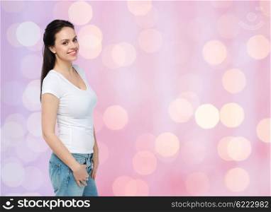 advertisement, clothing and people concept - happy smiling young woman or teenage girl in white t-shirt over rose quartz and serenity holidays lights background