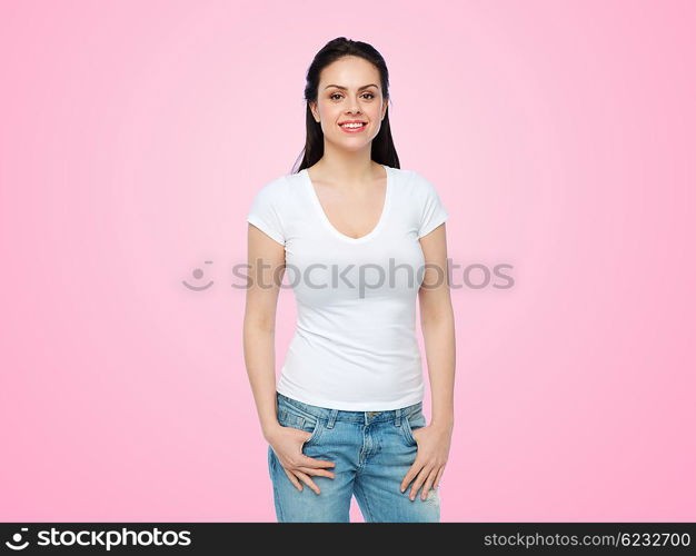 advertisement, clothing and people concept - happy smiling young woman or teenage girl in white t-shirt over pink background