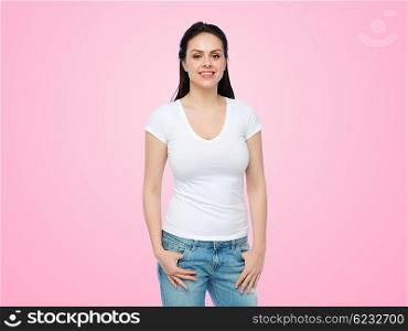 advertisement, clothing and people concept - happy smiling young woman or teenage girl in white t-shirt over pink background