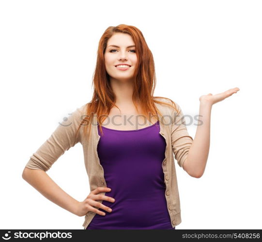 advertisement concept - attractive teenager in casual clothes holding something on the palm of her hand