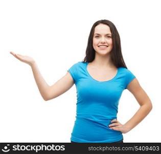 advertisement concept - attractive teenager in casual clothes holding something on the palm of her hand