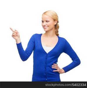 advertisement concept - attractive young woman in casual clothes pointing her finger