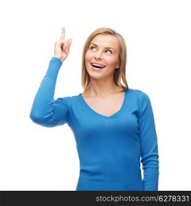 advertisement concept - attractive young woman in casual clothes pointing her finger up