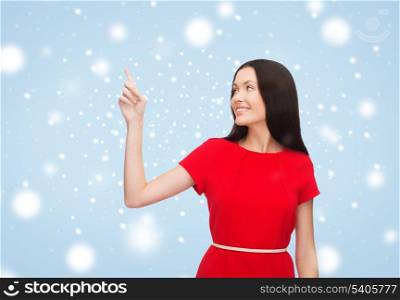 advertisement concept - attractive young woman in red dress pointing her finger