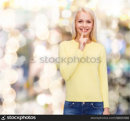 advertisement concept - attractive young woman with finger on her lip