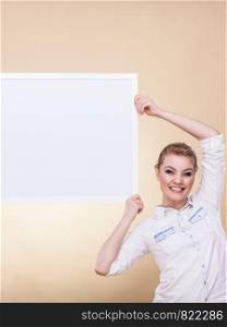 Advertisement concept. Teen smiling girl with blank presentation board. Young female student showing banner sign billboard copy space for text. Girl with blank presentation board