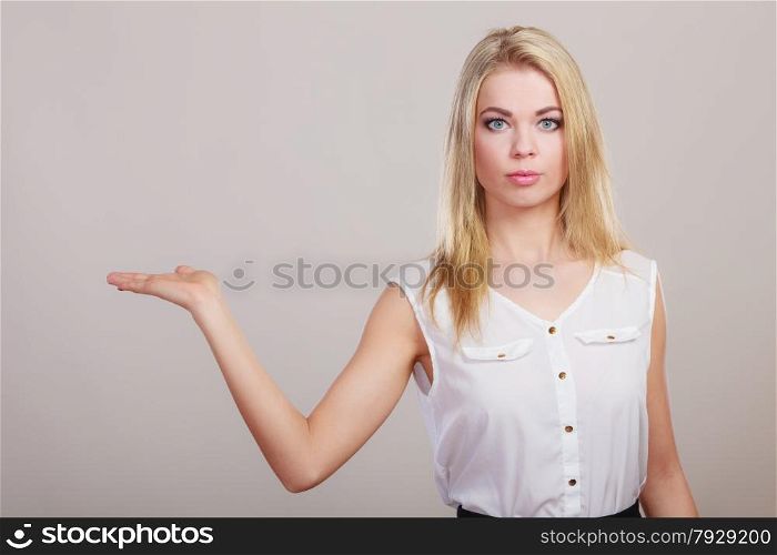 Advertisement concept. Young woman holding open palm empty hand showing copy space for product gray background