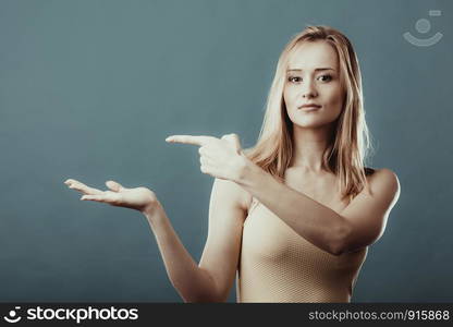 advertisement concept. Young woman holding open palm empty hand showing copy space for product on blue gray background